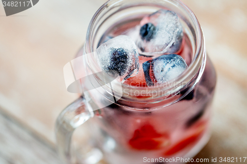 Image of close up of fruit water in glass mug on table