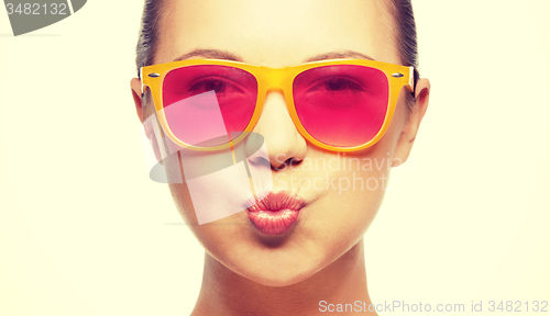 Image of girl in pink sunglasses blowing kiss