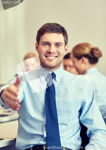 Image of group of smiling businesspeople meeting in office