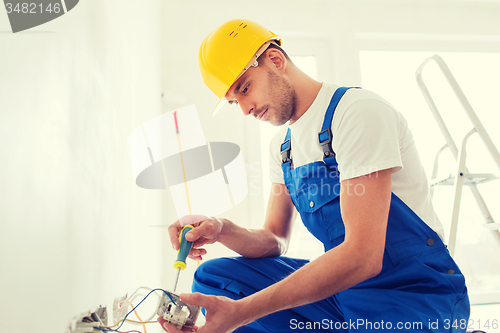 Image of builder with tablet pc and equipment indoors