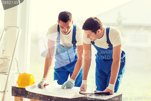 Image of group of builders with blueprint