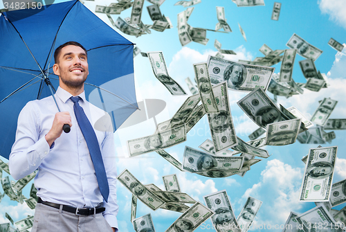 Image of young smiling businessman with umbrella outdoors