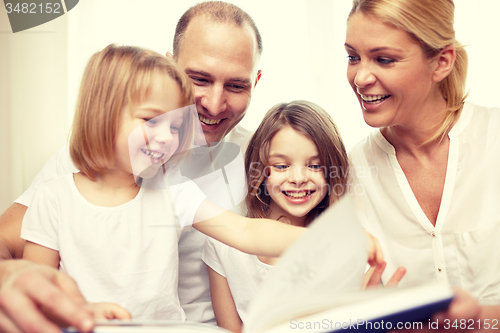 Image of happy family reading book at home