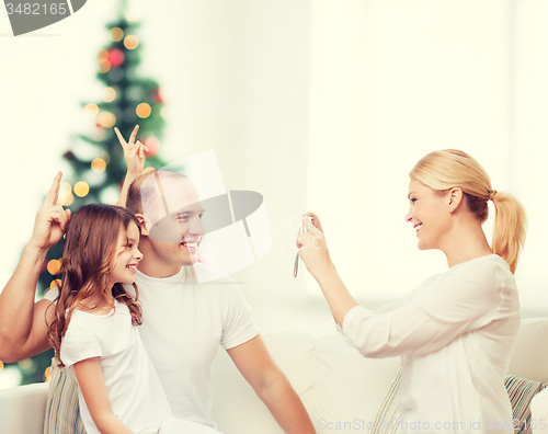Image of happy family with camera at home