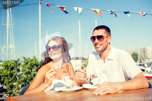 Image of smiling couple eating dessert at cafe