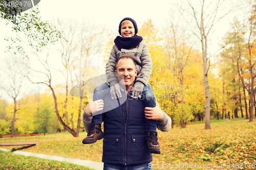 Image of happy family having fun in autumn park