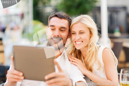 Image of happy couple with tablet pc at restaurant lounge