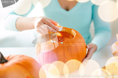 Image of close up of woman with pumpkins at home