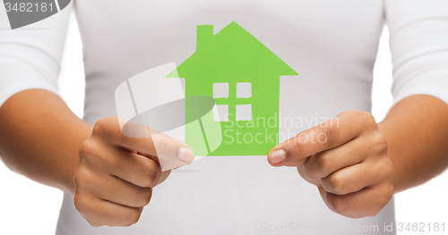 Image of woman hands holding green house