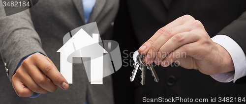 Image of businessman and businesswoman holding white house