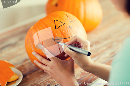 Image of close up of woman with pumpkins at home