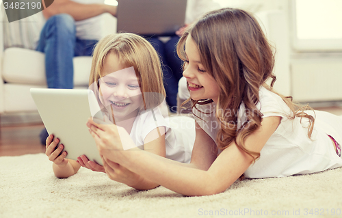 Image of happy little girls with tablet pc computer at home