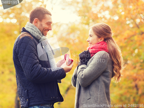 Image of smiling couple with engagement ring in gift box