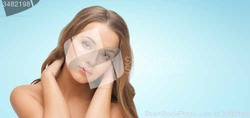 Image of beautiful young woman face over blue background