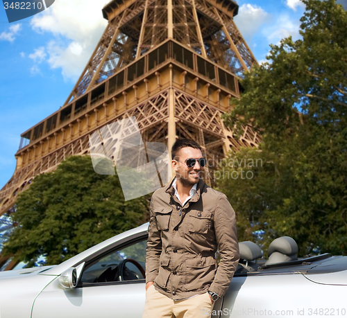 Image of happy man near cabriolet car over eiffel tower