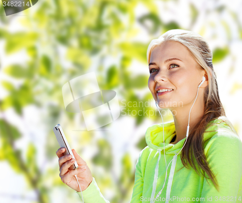 Image of happy woman with smartphone and earphones