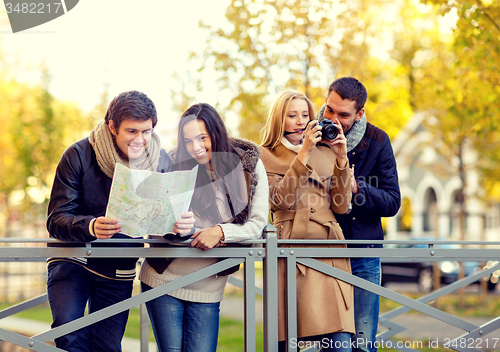 Image of group of friends with map and camera outdoors