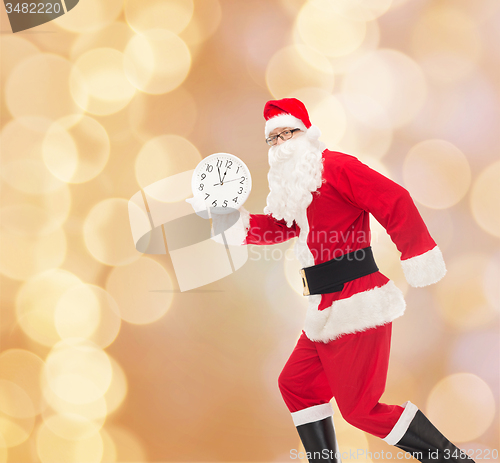 Image of man in costume of santa claus with clock