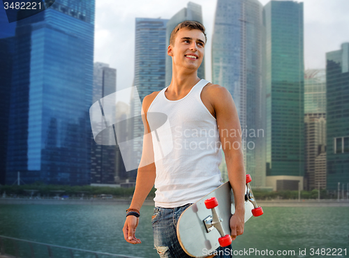 Image of smiling man with skateboard over singapore city