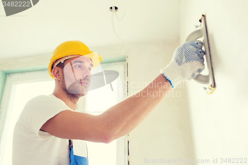 Image of builder working with grinding tool indoors