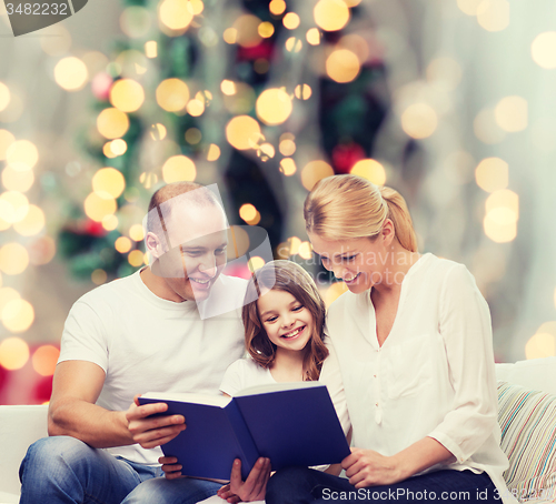 Image of happy family with book at home