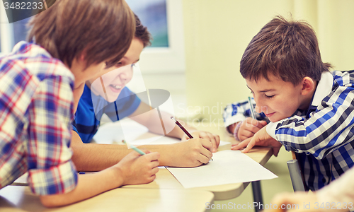 Image of group of schoolboys writing or drawing at school