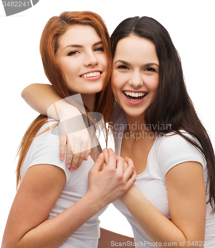 Image of two laughing girls in white t-shirts hugging