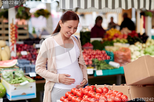 Image of pregnant woman choosing food at street market