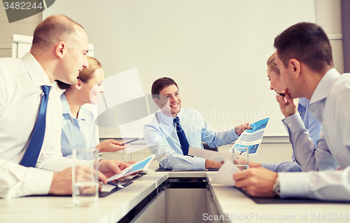 Image of group of smiling businesspeople meeting in office