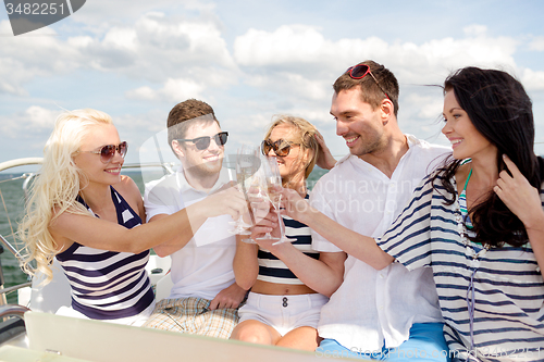 Image of smiling friends with glasses of champagne on yacht