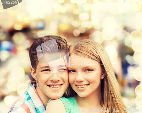 Image of smiling couple hugging over lights background