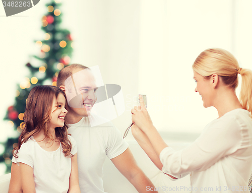 Image of happy family with camera at home