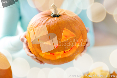 Image of close up of woman with pumpkins at home