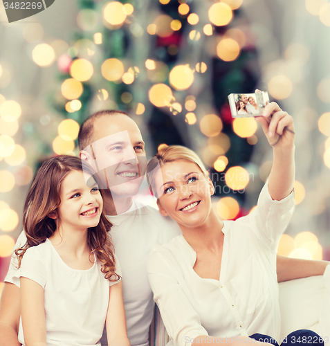 Image of happy family with camera at home