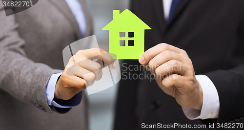 Image of businessman and businesswoman holding green house