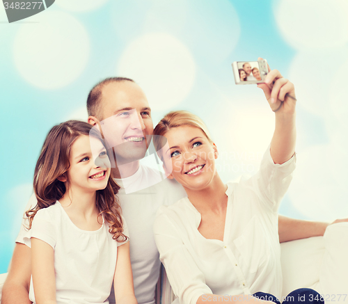 Image of happy family with camera at home