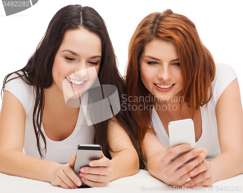 Image of two smiling teenagers with smartphones