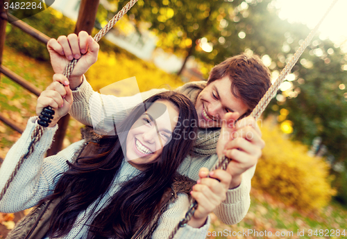 Image of smiling couple hugging in autumn park