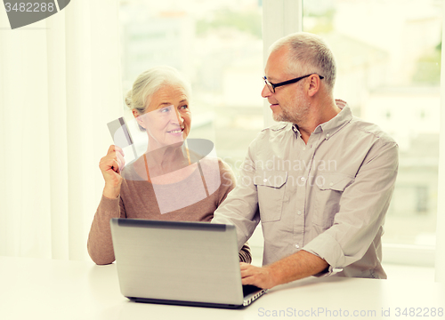 Image of happy senior couple with laptop and credit card