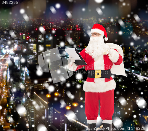 Image of man in costume of santa claus with notepad and bag