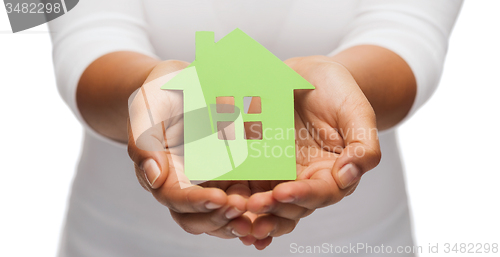 Image of woman hands holding green house