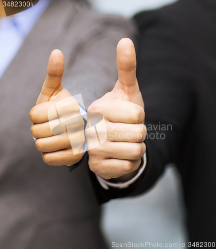 Image of businessman and businesswoman showing thumbs up