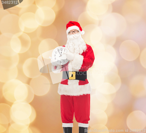 Image of man in costume of santa claus with clock