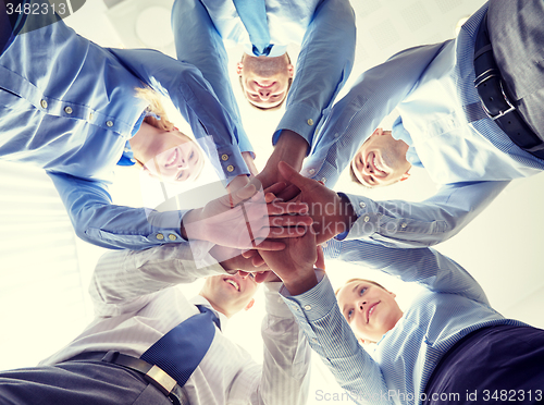 Image of smiling group of businesspeople standing in circle