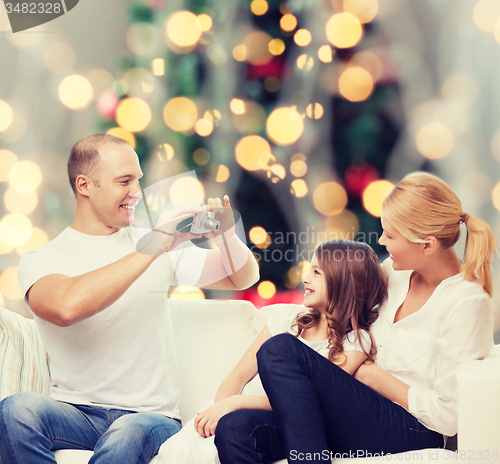 Image of happy family with camera at home