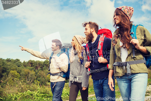 Image of group of smiling friends with backpacks hiking