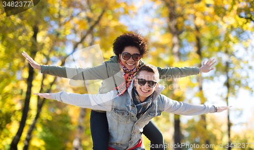 Image of happy teenage couple in shades having fun outdoors