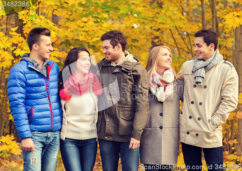 Image of group of smiling men and women in autumn park