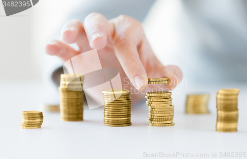 Image of close up of female hand putting coins into columns