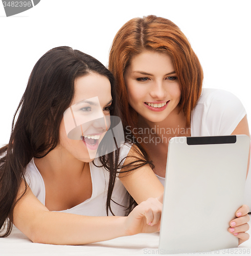 Image of two smiling teenage girls with tablet pc computer